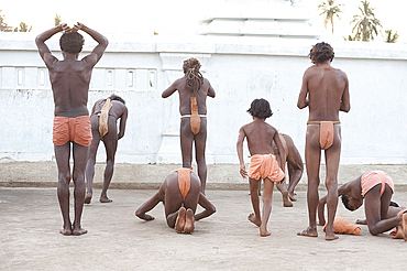 Joranda monks performing obeisance at temple containing a dhuni, an eternal butter lamp, at dusk, Joranda, Dhenkanal, Orissa, India, Asia