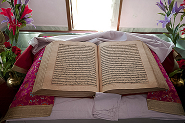 The Guru Granth Sahib, the Sikh holy book, at the 17th century Gurudwara Sri Guru Tegh Bahadur Sahib Sikh temple, Dhubri, Assam, India, Asia