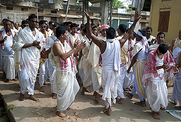 Men wearing Assamese white and red gamosa scarves and fresh white homespun dhotis in Durga puja religious procession, Sualkuchi, Assam, India, Asia