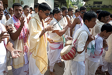 Hindu devotees wearing Assamese white and red gamosa scarves, drumming in Durga puja religious procession, Sualkuchi town, Assam, India, Asia