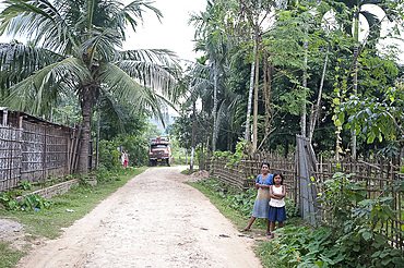 Mother and daughter in typical rural village street, Bijaynagar, Assam, India, Asia