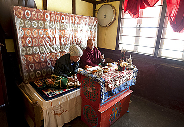 Two Buddhist men chanting their Buddhist mantra inside roadside tea stall at the Sela Pass, Tawang district, Arunachal Pradesh, India, Asia