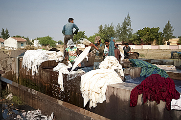 Men washing the starch out of cotton cloth in running water, before drying ready for indigo dyeing, Bhuj district, Gujarat, India, Asia