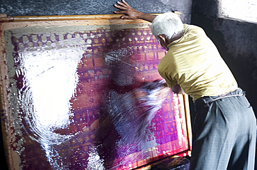 Man washing ink off screen used for printing sari lengths of cotton, Bhuj district, Gujarat, India, Asia