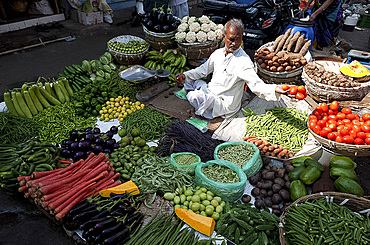 Subji wallah (vegetable seller) sitting at his beautifully laid out vegetable stall in the market, Ahmedabad, Gujarat, India, Asia