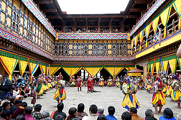 Monks performing religious ceremonial dances in the inner monastery courtyard at the Paro Tsechu (annual monastery festival), Paro, Bhutan, Asia