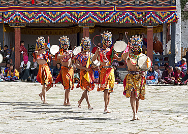 Masked dancers at Paro Dzong (monastery) performing ceremonial masked dance with drums, Tsechu (annual monastery festival), Paro, Bhutan, Asia