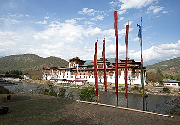 Prayer flags by Punakha dzong (monastery), at the confluence of the Pho chu (Father) and Mo Chu (Mother) rivers, Punakha, Bhutan, Asia