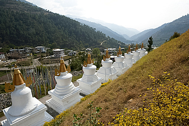 Row of white chortens at the entrance to Rangjung Buddhist monastery in the beautiful hills above Trashigang, Eastern Bhutan, Asia