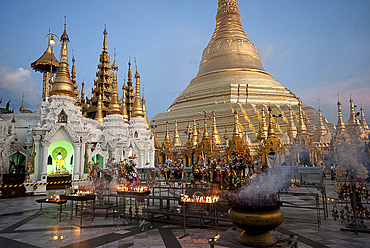 Lit candles placed by devotees at sunset at the Shwesagon Pagoda, a 2500 year old Buddhist pilgrimage site, Yangon, Myanmar (Burma), Asia