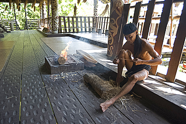 Orang Ulu tribesman whittling wood in traditional Orang Ulu longhouse, Sarawak Cultural Village, Kuching, Sarawak, Malaysian Borneo, Malaysia, Southeast Asia, Asia