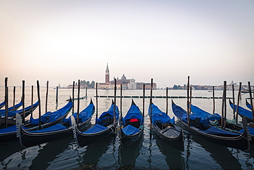 Gondolas moored on the Lagoon, San Giorgio Maggiore beyond, Riva degli Schiavoni, Venice, UNESCO World Heritage Site, Veneto, Italy, Europe