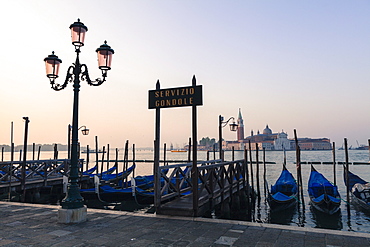 Gondolas moored on the Lagoon, San Giorgio Maggiore beyond, Riva degli Schiavoni, Venice, UNESCO World Heritage Site, Veneto, Italy, Europe