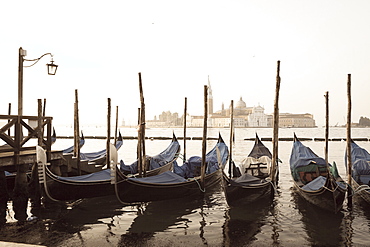 Gondolas moored on the Lagoon, San Giorgio Maggiore beyond, Riva degli Schiavoni, Venice, UNESCO World Heritage Site, Veneto, Italy, Europe