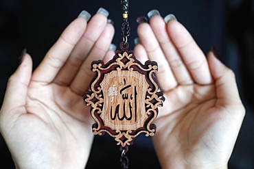 Close-up of the word Allah in Arabic calligraphy and woman praying, Vietnam, Indochina, Southeast Asia, Asia