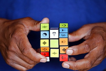 African man with a Rubik's cube with religious symbols, Interreligious and interfaith dialog concept, Madagascar, Africa