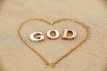 Wooden letters forming the word GOD with heart on a background of beach sand, Christian symbol, Vietnam, Indochina, Southeast Asia, Asia