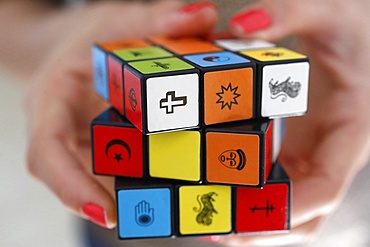 Woman with a Rubik's cube with religious symbols, Interreligious and interfaith dialog concept, Vietnam, Indochina, Southeast Asia, Asia