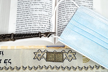 A silver Yad Jewish ritual pointer on a Torah and surgical mask, France, Europe