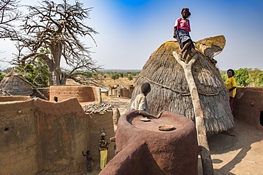 Old Batammariba woman standing in the granary on top of her takienta, the traditional earth tower house of Koutammakou region, La Kara, Togo, West Africa, Africa