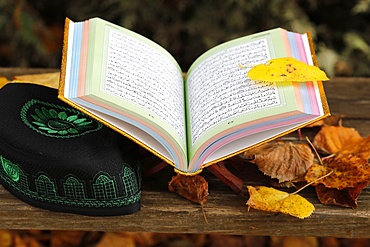 An open Holy Quran on wood stand and a kufi, France, Europe