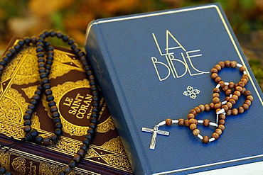 Holy Quran in French with Muslim prayer beads and Bible with rosary, Interfaith symbols between Christianity and Islam, France, Europe