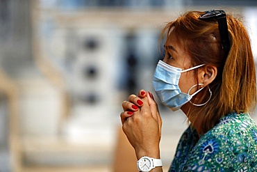 Woman with surgical mask praying in church during coronavirus epidemic (Covid-19), Venice, Veneto, Italy, Europe