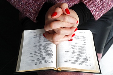 Woman reading the Bible at home, France, Europe