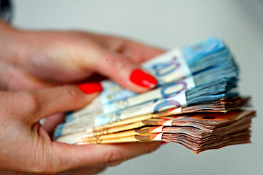 Woman holding euro money banknotes, concept of stealing cash, rich people, savings or spending money, counting payment, France, Europe