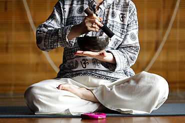 Tibetan bowl, Buddhist woman practising a singing bowl for sound therapy in atmosphere for healing, meditation, yoga and relaxation, Quang Ninh, Vietnam, Indochina, Southeast Asia, Asia