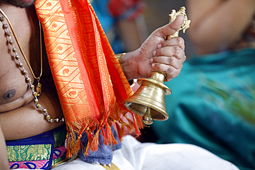 Hand holding ceremonial bell, Sri Srinivasa Perumal Hindu temple, Hindu priest (Brahmin) performing puja ceremony and rituals, Singapore, Southeast Asia, Asia