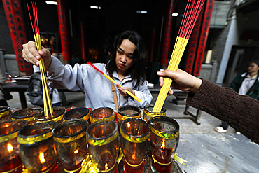 The Thien Hau Temple, the most famous taoist temple in Cholon, woman praying with burning incense sticks, Ho Chi Minh City, Vietnam, Indochina, Southeast Asia, Asia