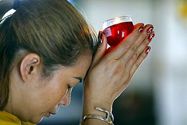 Woman at Buddhist ceremony praying with a candle, Huynh Dao Buddhist Temple, Chau Doc, Vietnam, Indochina, Southeast Asia, Asia