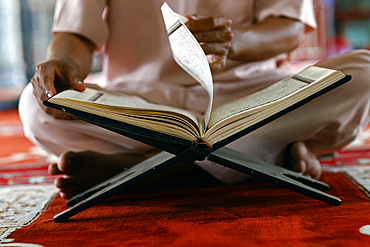 Muslim man sitting reading the Quran (Koran) the holy book of Islam, Mubarak Mosque, Chau Doc, Vietnam, Indochina, Southeast Asia, Asia