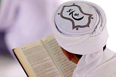 Muslim man reading an Arabic Holy Quran (Koran), Jamiul Azhar mosque, Vietnam, Indochina, Southeast Asia, Asia