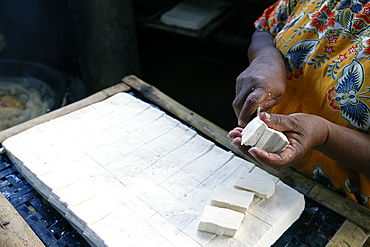 Worker making tofu in a traditional family factory. Tofu is a food prepared by coagulating soy milk. Yogyakarta. Indonesia.