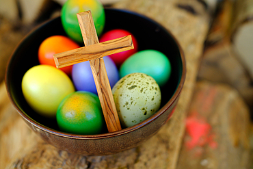 Colored Easter eggs with a wooden cross, for The Resurrection of Christ, most ancient Christian holiday, France