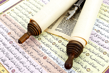 Torah scrolls in Hebrew, yad and quran in Arabic. Relationship between Muslims and Jews. Interfaith and peace concept.