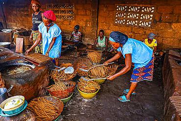 Women working in a workshop where peanuts are transformed into klui klui sticks in central Benin