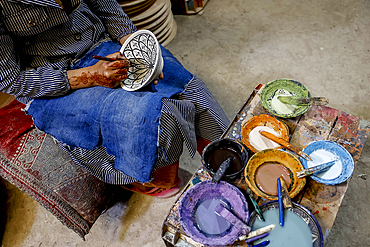 Worker painting bowls in a pottery workshop, Safi, Morocco
