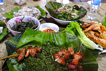 Traditional festive meal in a village on the highlands. Rice cooked over a wood fire in a bamboo pot. Kontum. Vietnam.