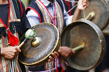 Traditional ceremony in a Bahnar ethnic village in the Kontum region. Young people in traditional clothing playing percussion instruments. Kontum. Vietnam.