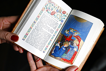 Catholic woman reading an illustrated missal. The Coronation of the Virgin in Heaven.