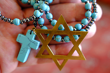 Two monotheistic religions, Christianity and Judaism. A rosary and a star of David. Religious symbols.