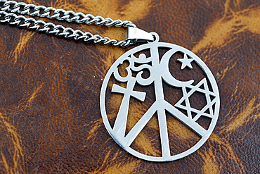 Pendant with symbols of major religions. Christianity, Judaism, Hinduism. Cross, Star of David, crescent and Om. Symbol of peace and interfaith dialogue.