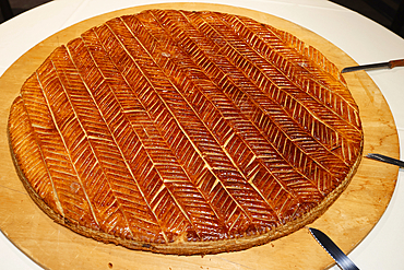 Galette des Rois (French King Cake) with Feve and Crown usually shared on the Epiphany to celebrate the arrival of the Three Wise men in Bethlehem.