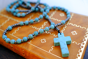 Old holy bible with a leather cover and a Rosary.