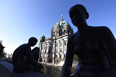 Silhouettes of riverside figure sculptures, Dom (Cathedral) beyond, Spree River, Berlin, Germany, Europe