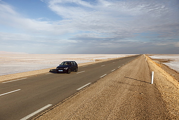 Chott El Jerid, a flat dry salt lake, and automobile on highway between Tozeur and Kebili, Tunisia, North Africa, Africa