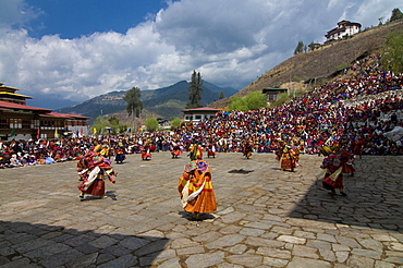 Costumed dancers at religious festival with many visitors, Paro Tsechu, Paro, Bhutan, Asia